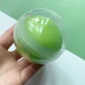 Detailed view of green squeeze stress relief toy inside clear capsule for office use. - Green Grape Crispy Style / 1 Piece / Green