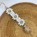 Silicone daisy flower pacifier clip with natural wooden beads and secure metal clasp for babies. - White