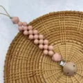 Detailed view of the silicone beaded baby pacifier clip with secure metal clasp chain. - Pink Round Bead