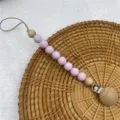 Silicone wooden pacifier clip detail shot, baby teething chain with purple beads and metal clasp. - Light Purple