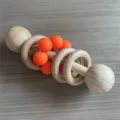 Hölzerne Silikon Baby Rasselspielzeug mit hellorangen Perlen und Holzringen für Babys. - Orange