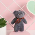 Primer plano de un llavero de peluche de oso gris con un lazo de cinta. - 12cm / Gris