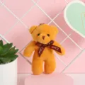 Primer plano de un lindo llavero de oso de peluche naranja con cinta impresa Love - 12cm / Marrón