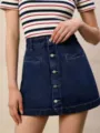 Primo piano dettagliato della mini gonna in denim blu scuro da donna con bottoni frontali. - Taglia S / Blu scuro