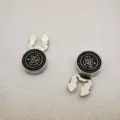Gedetailleerd shot van vintage metalen knopen met anker- en schedelmotief voor vesten. - Zilver