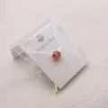 Gedetailleerd detailgezicht van een stijlvolle heren daspin met een rode kristallen steen op kaart. - Metallic zilveren verzilvering / Rood