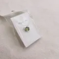Groene edelsteen stropdas speld broche op witte displaykaart veilig verpakt in zak. - Lichtgroen