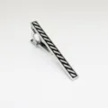 Metalene dasclip detail met stijlvol zwart-wit diagonaal gestreept emaille patroon duidelijk. - Diagonale Strepen Stijl / Zilver