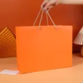 Large orange rectangular paper gift bag with handles for birthdays, weddings and parties. - Simple Plain Orange Tote Bag