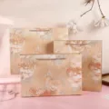 Orange floral gift bags, thick paper shopping bags with elegant handles for retail and presents. - Ink Champagne Bag