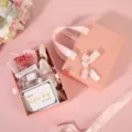 Coffret cadeau rose avec lapin en peluche mignon, fleurs séchées et carte pour belles fêtes. - Boîte rose à tiroir avec nœud à liseré doré + raphia + carte + bouquet + guirlande lumineuse + lapin