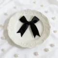 Primer plano detallado de un lazo de satén negro, ideal para decoración de cajas de regalo. - Negro