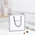 White paper gift bag with black borders, large minimalist shopping tote for retail packaging. - 21x22x9.5cm