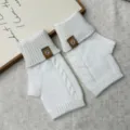 Nahaufnahme von weißen Winter-Strickhandschuhen ohne Finger mit Zopfmuster und Bündchen. - Einheitsgröße / Weiß