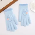 Detailaufnahme blauer kuscheliger Strickhandschuhe mit niedlichem Herzmuster für warme Hände. - See-Blau