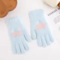 Detailed shot of light blue knit gloves with cute pink butterfly pattern for winter. - Lake Blue