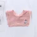 Close-up detail of a charming pink baby saliva bib featuring delicate red dotted trim patterns. - Pink