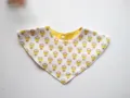 Detailed view of baby triangle bib, soft cotton fabric with yellow floral print, snap button. - Pineapple