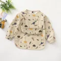 Waterproof long sleeve baby bib with cute dinosaur print, soft PU feeding smock for toddlers. - Size L (24-36 Months) / PU Bib with Top Pocket - Beige Dinosaur