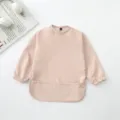 Babero impermeable de manga larga para bebé en rosa claro con bolsillo, ideal para la hora de comer. - Color sólido