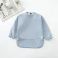Babero impermeable de manga larga para bebé en azul claro con práctico bolsillo atrapamigas. - Azul claro