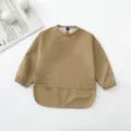 Vista detallada del babero impermeable de manga larga para bebé en caqui con bolsillo. - Café Oscuro
