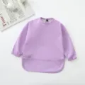 Vista detallada del babero impermeable de manga larga para bebé en morado claro con bolsillo. - Púrpura