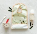 Detailed view of baby waterproof bib featuring cute olive print, soft material for feeding time. - Green Olive Branch