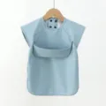 Detailed view of the blue baby bib showing waterproof PU fabric and convenient front crumb pocket. - Blue