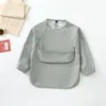Waterproof long-sleeve baby bib and smock in solid grey-green with large front pocket for feeding. - Size S for 6-12 Months / Sage Green