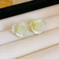 Detailansicht der mehrschichtigen Rosenohrringe, frischer Stil, elegante Ohrstecker. - Gelb