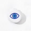 Detail view of the portable folding hair brush with a chic evil eye design and mirror. - Style B