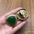 Detalle de pendientes vintage con piedra verde triangular y diseño de metal dorado. - Pendientes de Clip / Verde