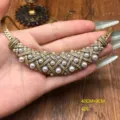 Primer plano del collar vintage de malla con perlas y diamantes en mano, detalles brillantes. - Collar / Oro Antiguo