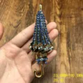 Close-up of exquisite blue rhinestone umbrella brooch detail, shiny gold alloy fashion accessory. - Umbrella Brooch