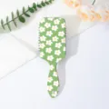 Detailed view of the cute green daisy floral air cushion hair comb, showing fine pattern texture. - Letter A