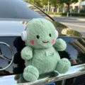 Simpatica bambola di peluche verde con cuffie ciondolo per bagagliaio posteriore auto - Dinosauro