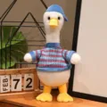 Morbido peluche papera con gambe lunghe, cappello blu e maglione per un regalo ideale. - Anatra in piedi con vestiti blu e righe rosse