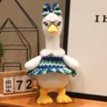 Graziosa anatra di peluche con occhiali e vestito a maglia, perfetta decorazione festiva. - Stile in piedi con occhiali - Gonna a strisce blu e verdi