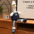 Simpatico peluche di anatra a gambe lunghe con occhiali e vestito a righe per bambini. - Anatra a zampe lunghe con occhiali - Salopette di jeans