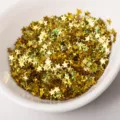 Vue détaillée de paillettes dorées en forme d'étoile dans un bol pour art des ongles. - Or Holographique