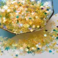 Détail rapproché de paillettes en résine en forme de flocon de neige holographiques pour loisirs. - Série Jaune