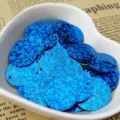Close-up detail of blue holographic round sequins with hole for DIY crafts and clothing decor. - Holographic - Dark Blue