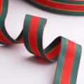 Primer plano detallado de cinta navideña a rayas rojas y verdes con borde dorado para regalos. - Cinta Acanalada a Rayas Rojo y Verde / 25mm de Ancho Paquete de 2m / Rojo y Verde