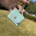 Primo piano di un mini portachiavi a forma di borsa di paillettes verde pastello - portachiavi per borse / Ricamo Piatto Verde