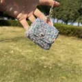 Close-up view of a sparkling sequin mini bag keychain charm featuring a golden ring - Bag Charm / Embroidered Grey