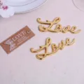 Dettaglio apribottiglie in metallo Love dorato, perfetto accessorio come favore di nozze. - Oro