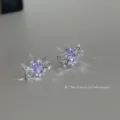 Gros plan des boucles d'oreilles nœud creux en zircon violet élégant avec des pierres scintillantes. - Style Clous / Violet Argent