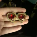 Vista detallada de pendientes de corazón vintage rojos con hojas doradas talladas y pedrería. - Pendientes de botón / 24.5x22mm / Rojo