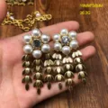 Vista detallada de pendientes vintage perlas flores cristal con borlas doradas, elegantes. - Pendientes de Botón de Perlas